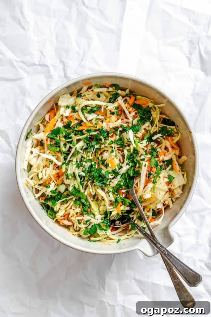 Bright & Tangy Mayo-Free Coleslaw 10 Healthy Coleslaw with serving spoons in a bowl