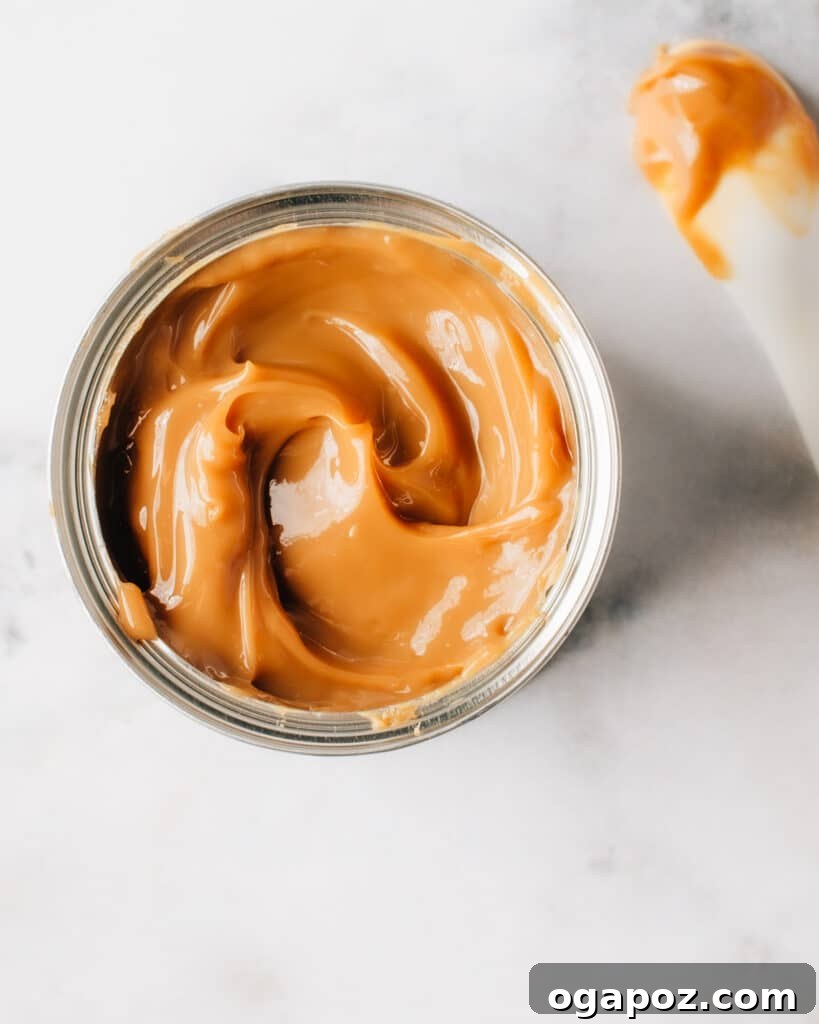 Cloud-Soft Pumpkin Cupcakes 7 Homemade caramel sauce in a glass jar, perfect for drizzling.