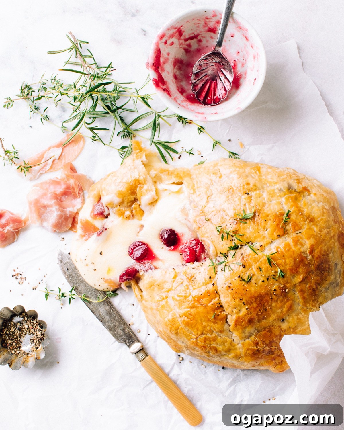 Gourmet Brie & Prosciutto Puff Pastry with Cranberries 2 Golden brown puff pastry baked brie with prosciutto and cranberries, ready to be served