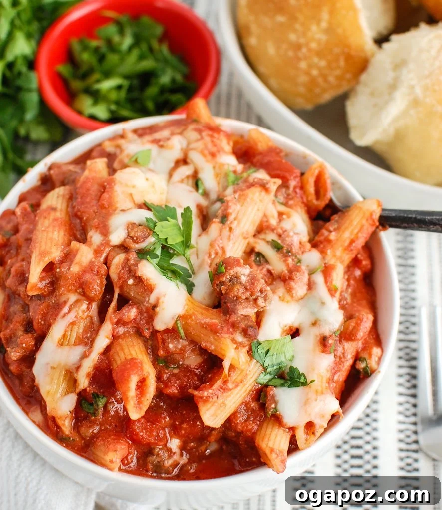 Creamy Ricotta Baked Ziti 4 Scoop of Baked Ziti with Ricotta on a fork, showing the layers of pasta, sauce, and melted cheese