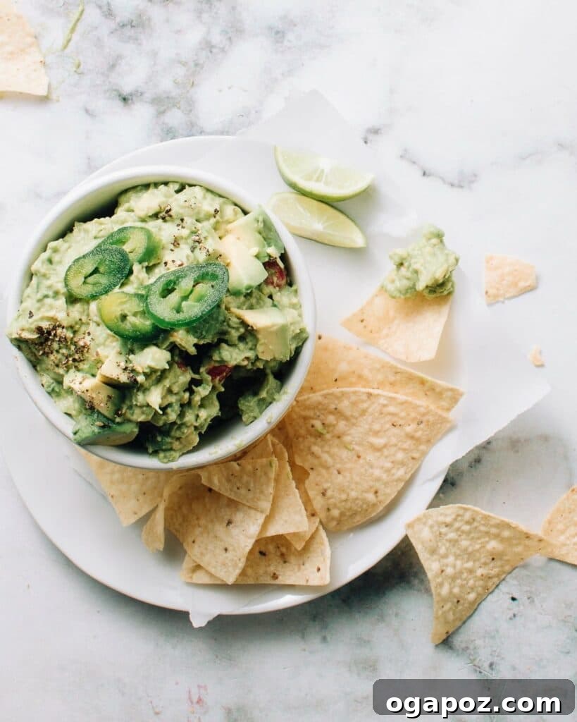 Ultimate Game Day Grub 16 Authentic mexican guacamole in a bowl with jalapenos on top.