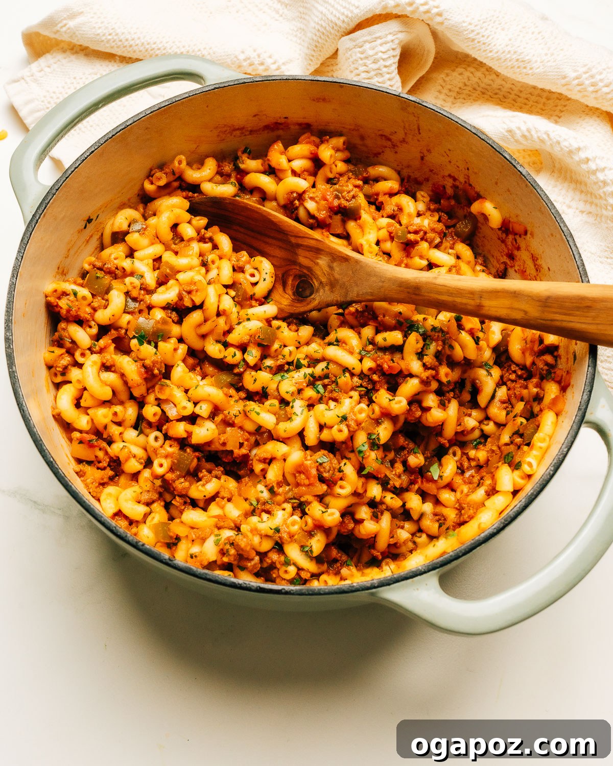 Hearty American Macaroni Bake 2 American Chop Suey Recipe in a pot with a wooden spoon.