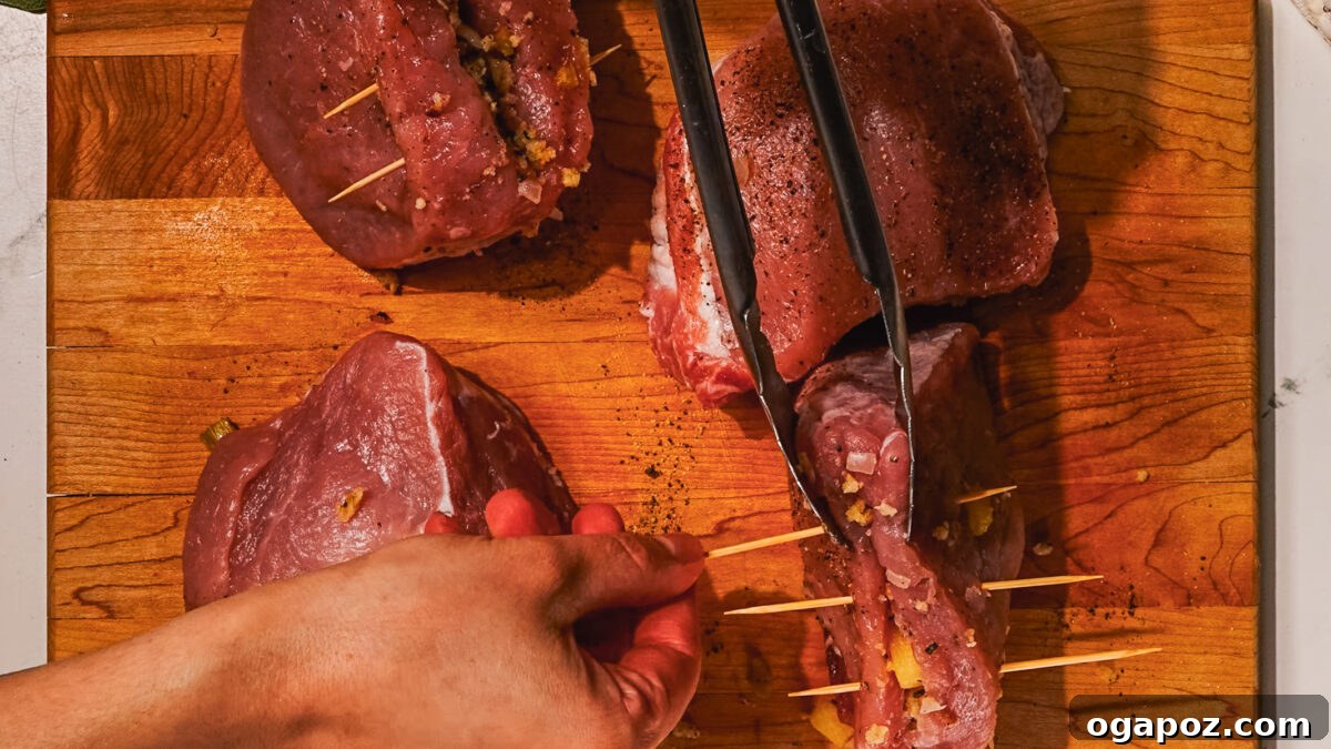 Signature Stuffed Pork Chops with an Unforgettable Pan Sauce 6 Step 3: Stuffing a thick-cut pork chop with the prepared sausage and apple mixture.