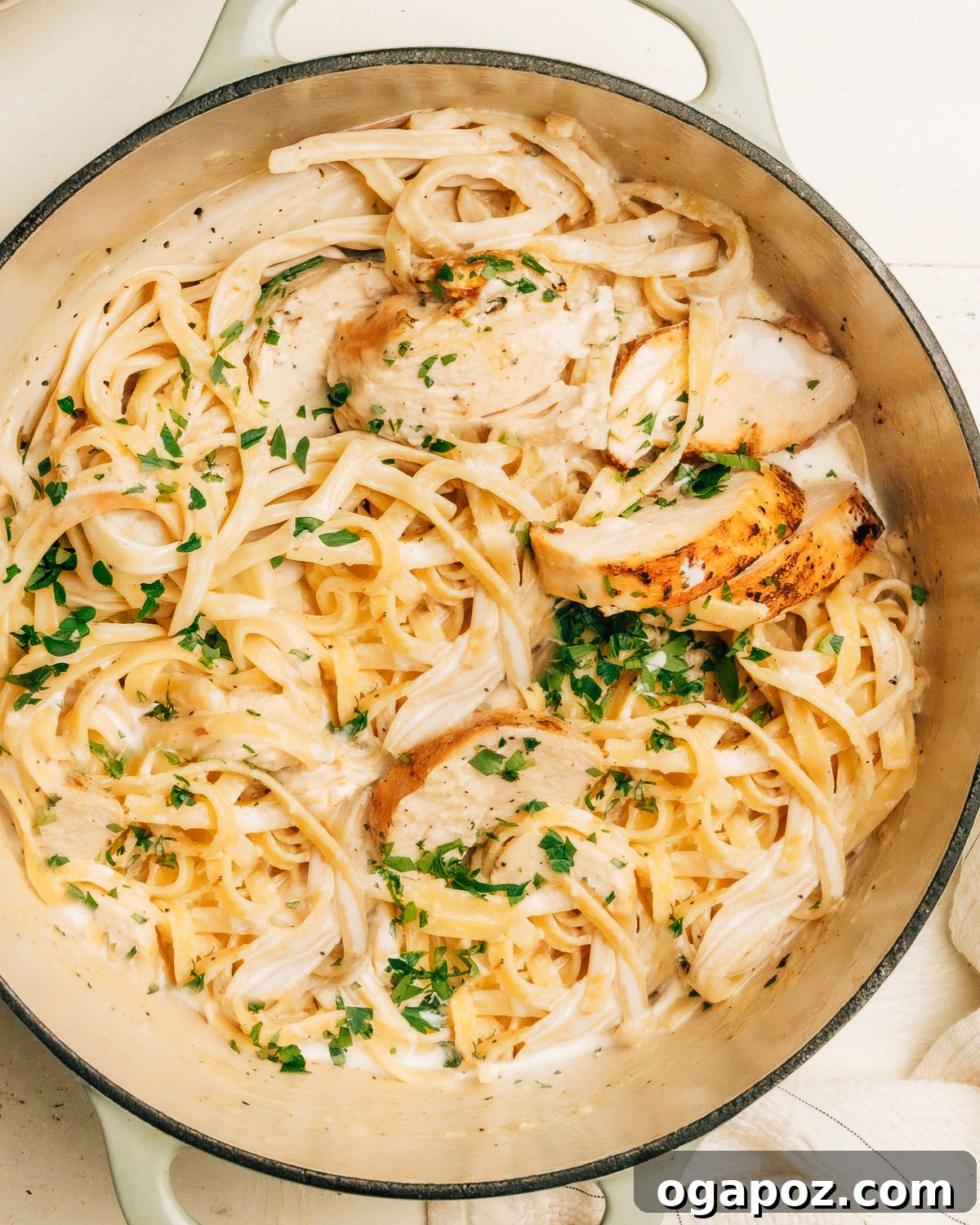 Rich and Creamy Chicken Alfredo 8 Close up of creamy chicken Alfredo, showing perfectly coated fettuccine, sliced chicken, and fresh parsley garnish.