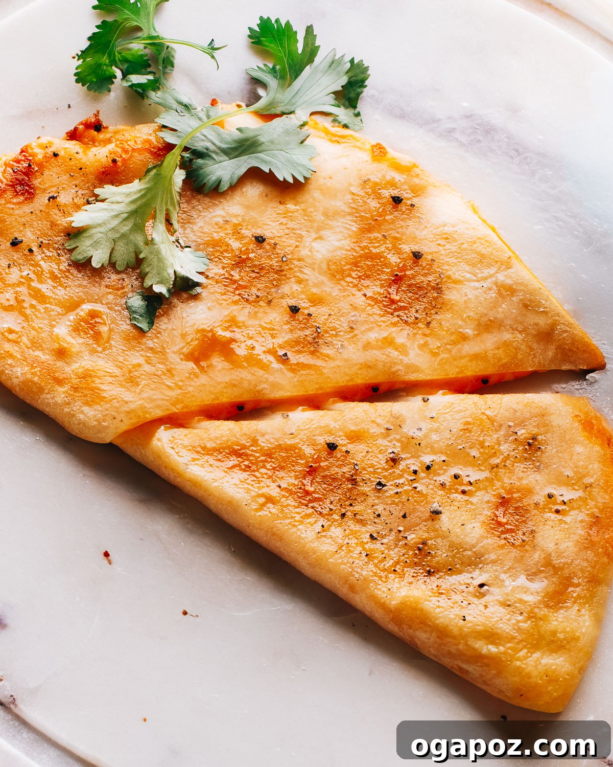 Ultimate Chicken Quesadilla 2 Crispy chicken quesadilla recipe served on a marble plate with a side of sour cream.