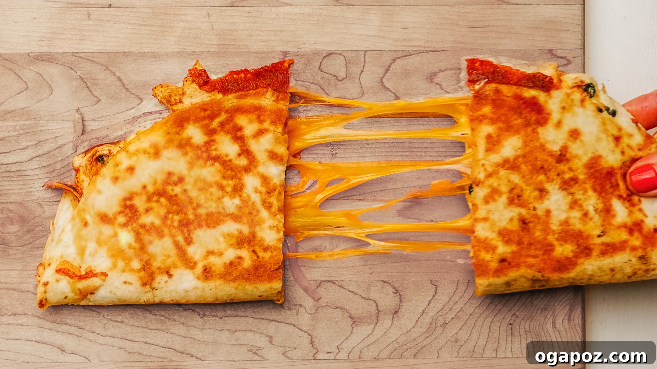 Ultimate Chicken Quesadilla 4 A close-up of a chicken quesadilla with melted cheese stretching as it's pulled apart.