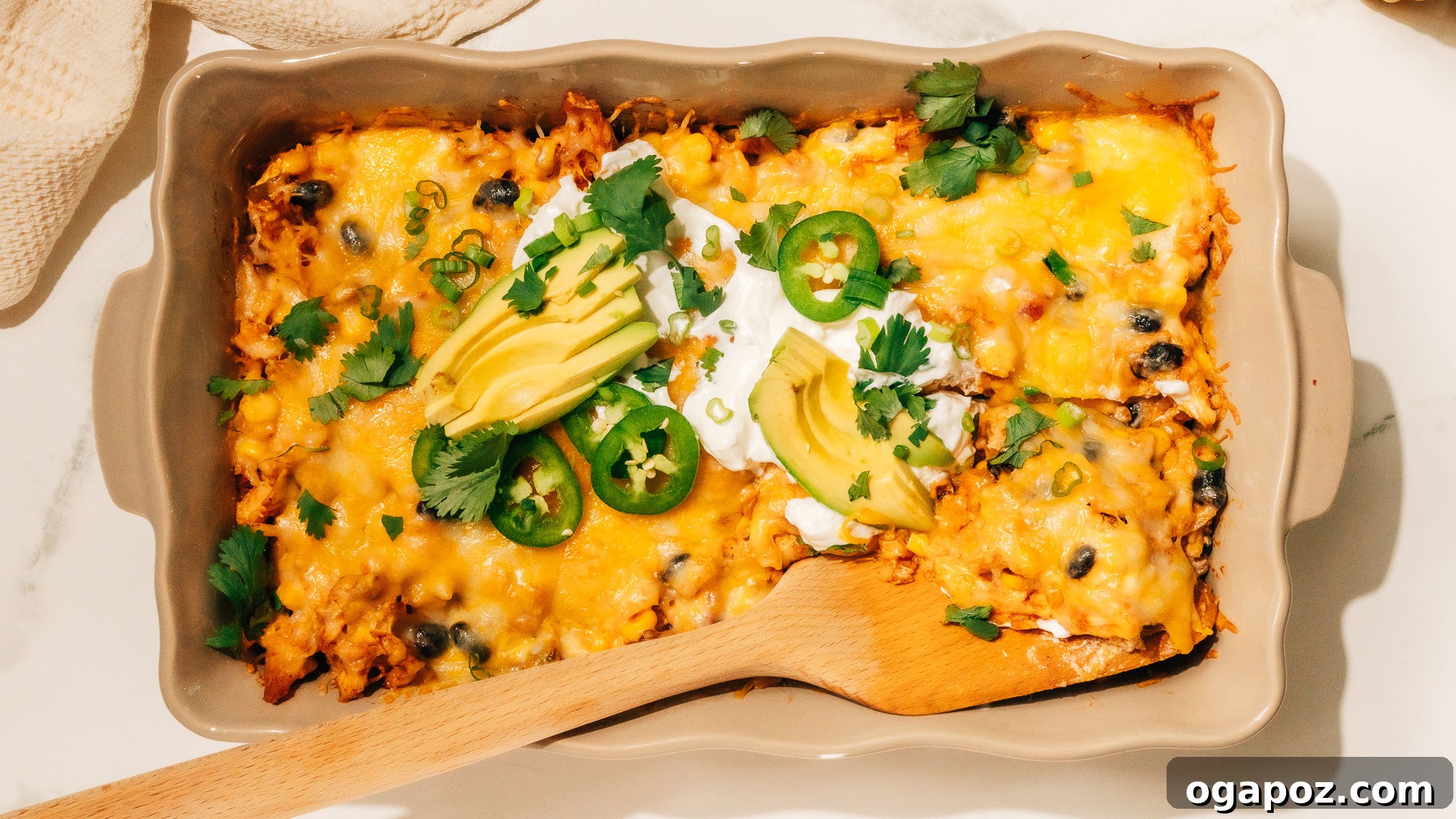 Fiesta Chicken Bake 9 A serving of Mexican Chicken Casserole being scooped from the baking dish with a spatula, showing the layers of cheesy goodness.