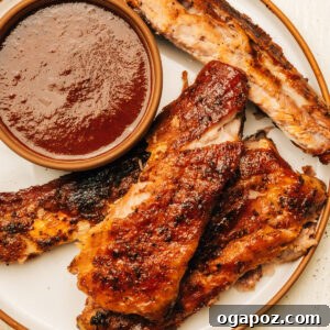 Fork Tender Spare Ribs 10 Spare ribs on a plate with barbecue sauce.
