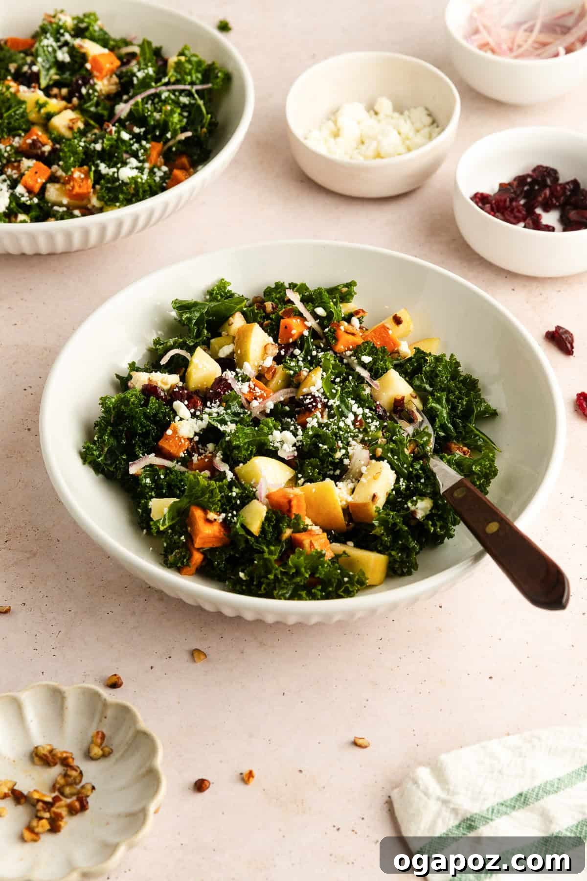 A large serving bowl filled with the hearty Kale and Sweet Potato Salad, garnished with fresh herbs.
