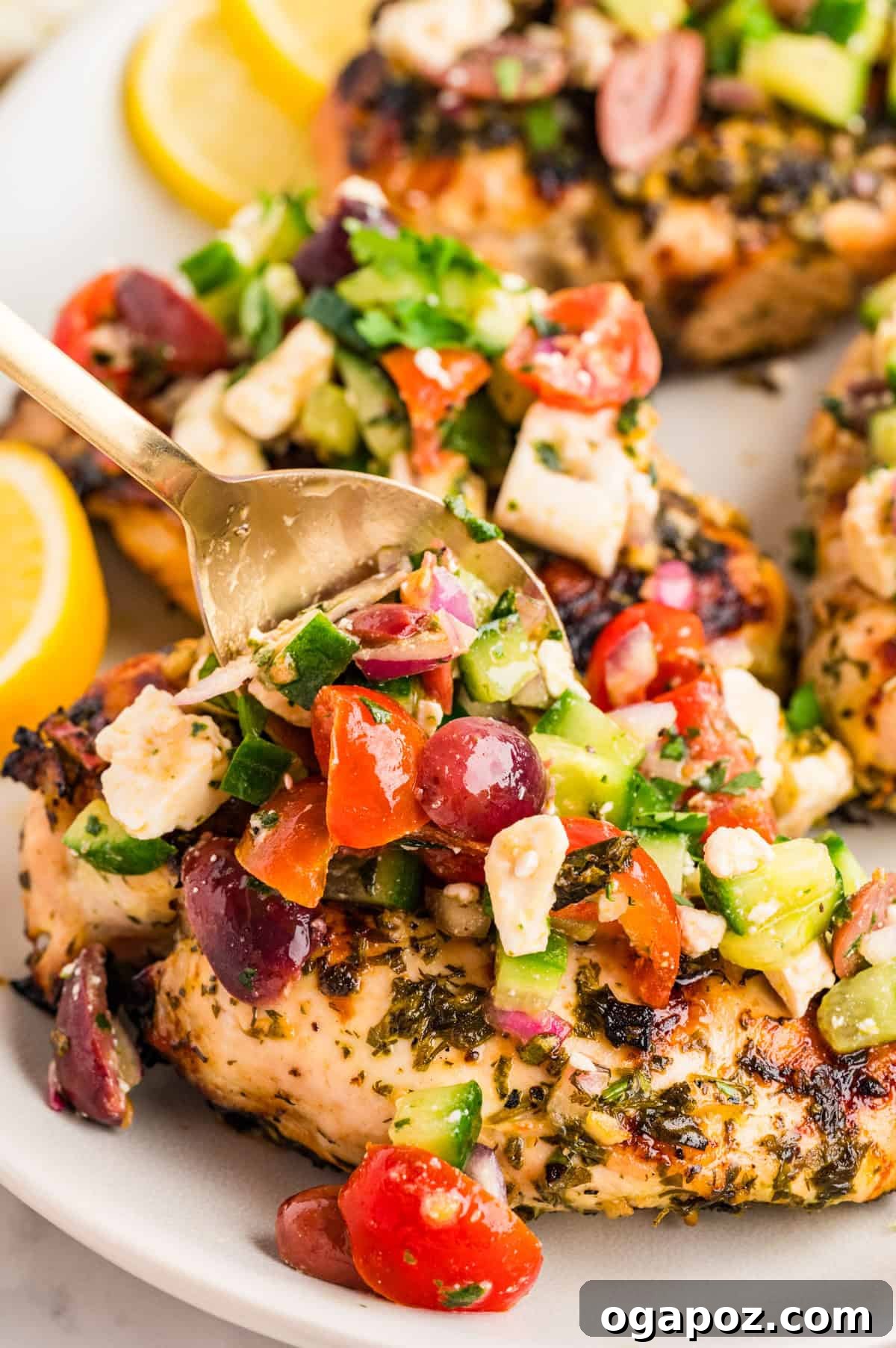 Close up of the colorful Mediterranean chicken topping, featuring diced cucumber, halved cherry tomatoes, sliced Kalamata olives, and crumbled feta cheese.