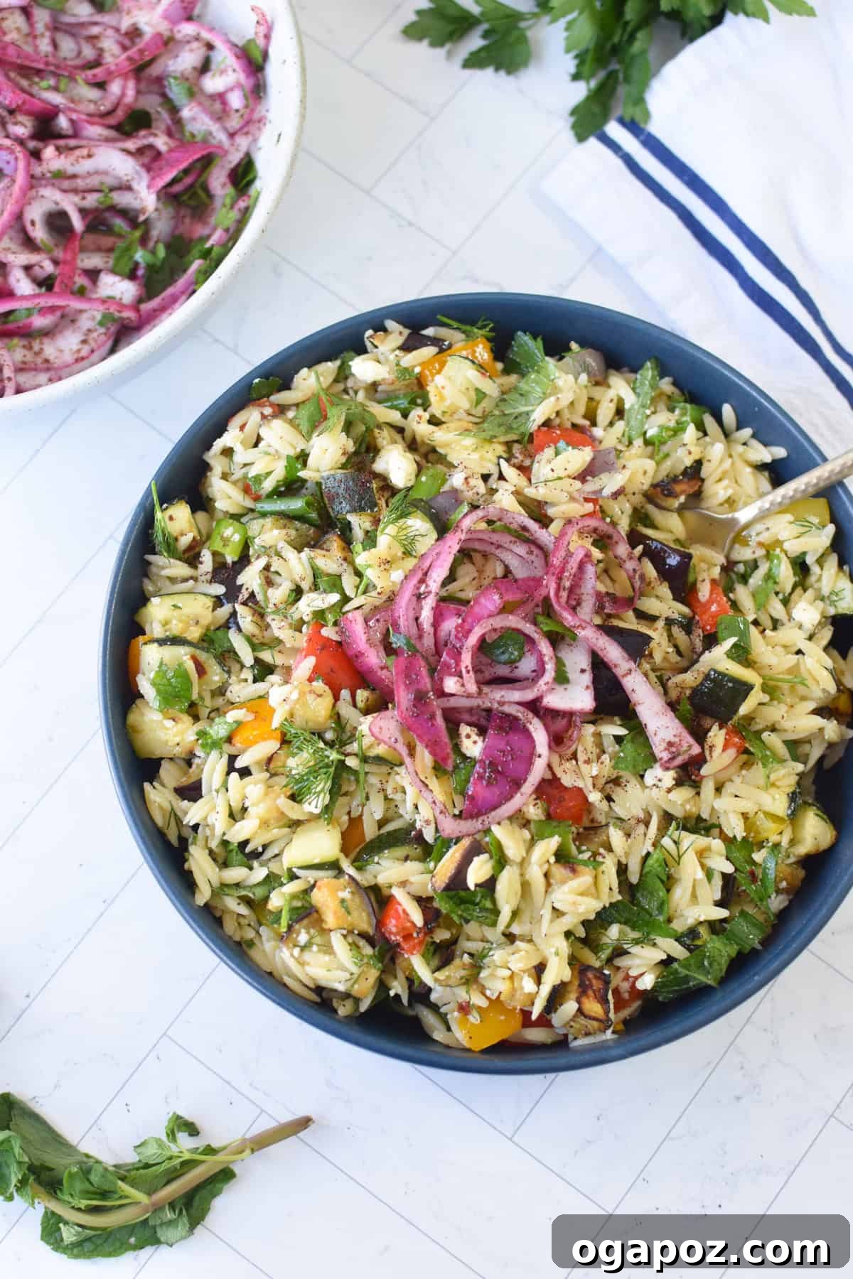 Mediterranean Roasted Vegetable Orzo Salad with Feta 10 Easy Mediterranean Roasted Vegetable Salad with Feta Cheese, garnished with fresh herbs in a white serving bowl