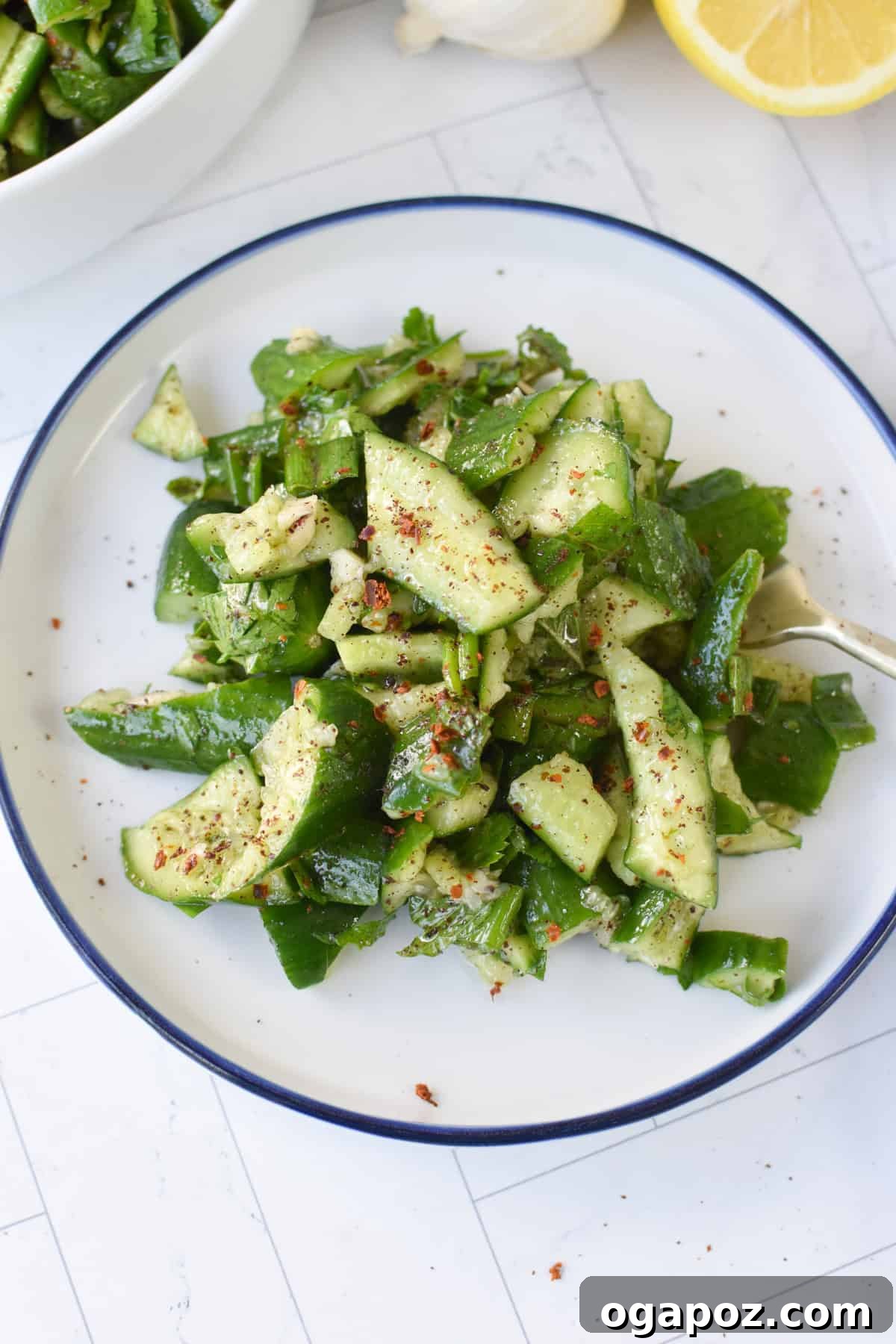Close-up of Tangy Smashed Cucumber Salad with Sumac and Lemon Dressing, highlighting the jagged cucumber pieces and fresh herbs.