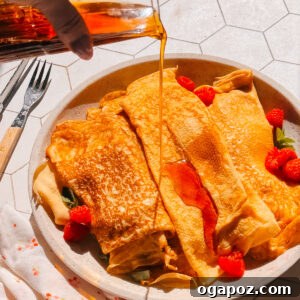 Authentic French Crêpe Recipe: Step-by-Step Guide for Perfect Crepes 4 Finished French crepe recipe on a plate with maple syrup and raspberries.