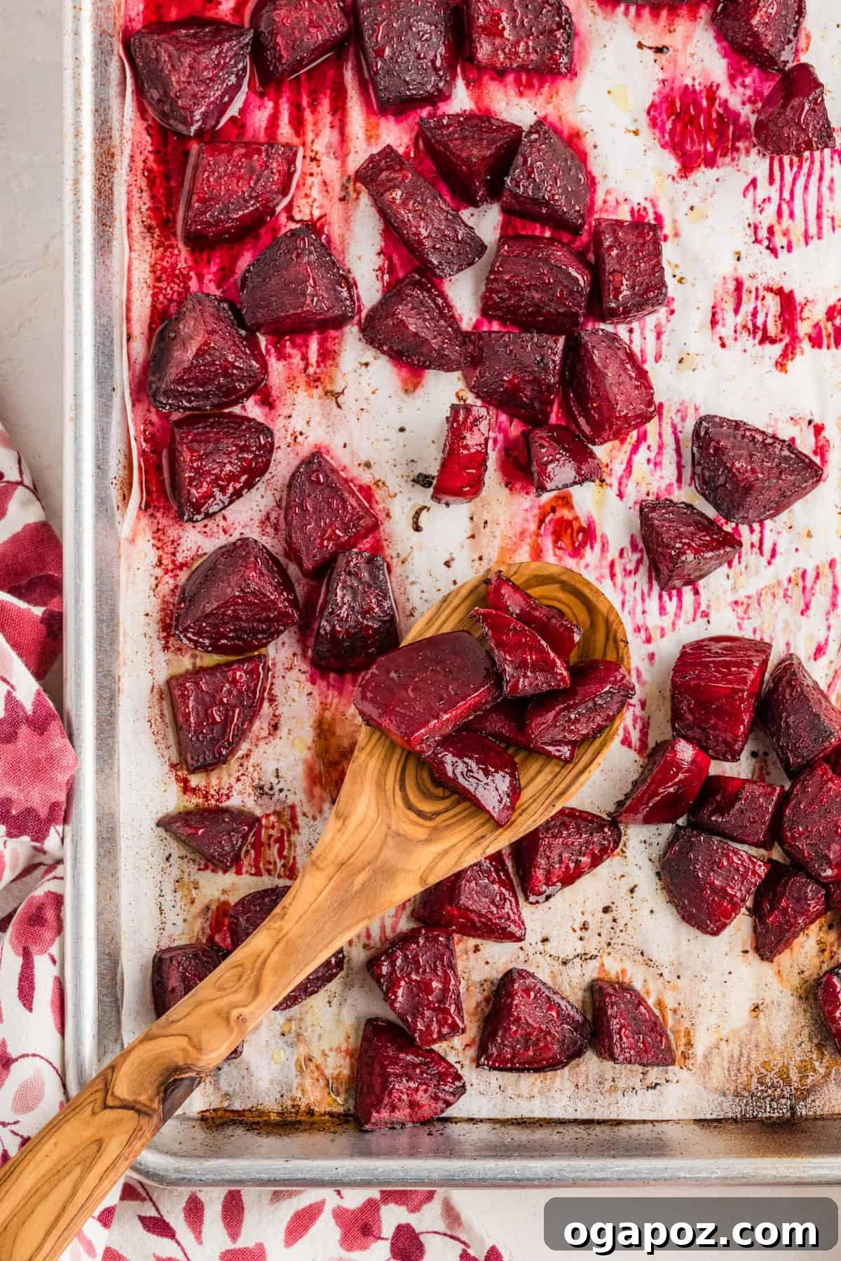 Quick Oven-Roasted Beets in 30 Minutes (No Foil) 9 Roasted beets on a baking sheet with a wooden spoon