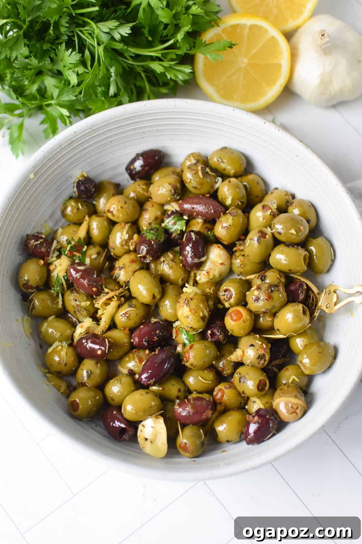 Warm Lemon-Herb Olives with Mediterranean Spices — 10-Minute Appetizer 6 Warm olives with lemon and Mediterranean herbs in a white bowl