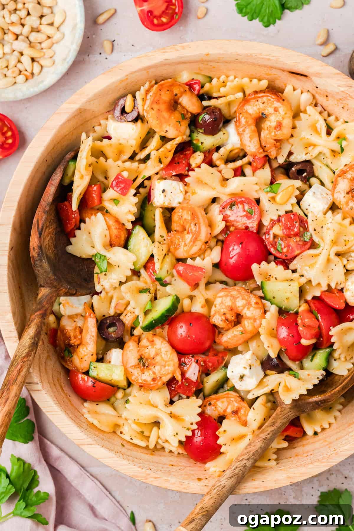 Make-Ahead Mediterranean Shrimp Pasta Salad for Summer Meals 2 Farfalle pasta salad with seasoned shrimp, cherry tomatoes, cucumber, and feta cheese