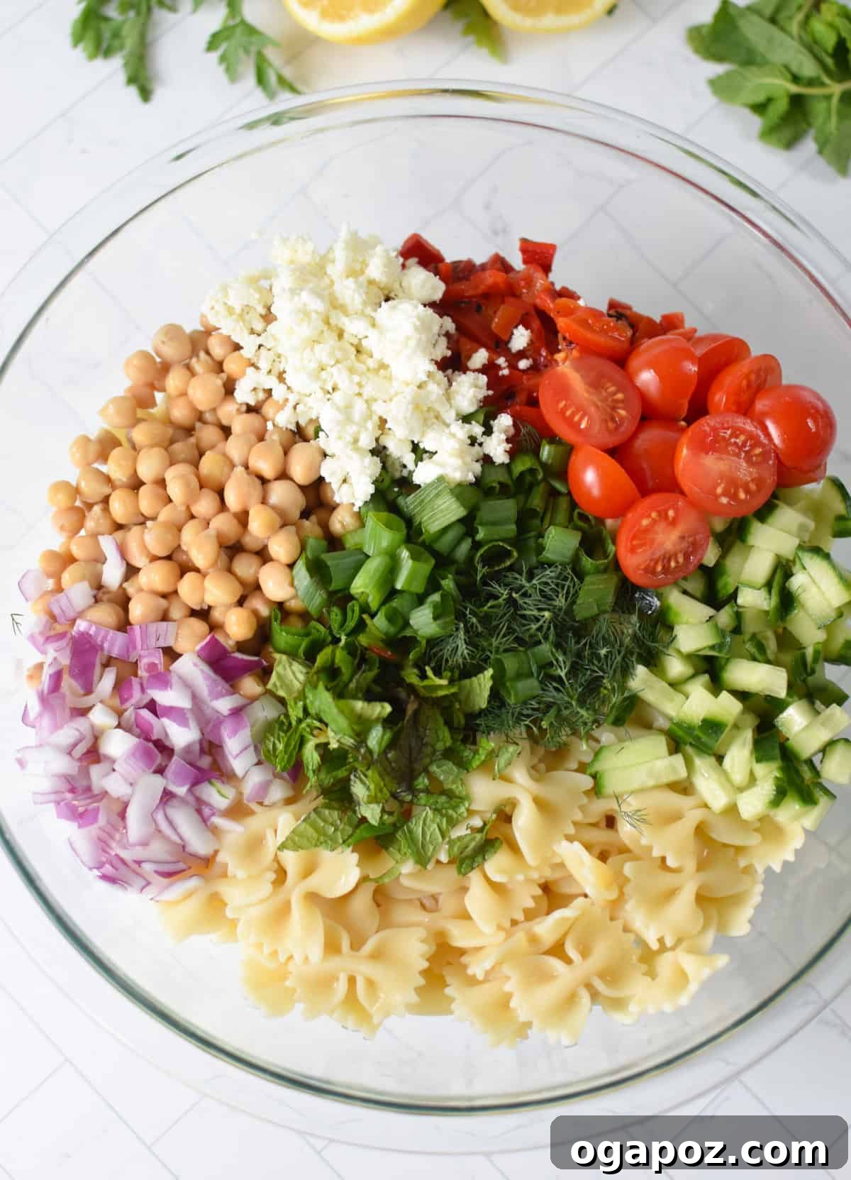 Mediterranean Bow-Tie Pasta Salad with Feta & Olives 8 Bow Tie Pasta Salad ingredients in a glass bowl