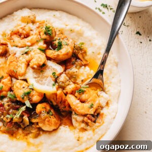 Creamy Southern Shrimp and Grits Recipe for Weeknight Dinner 12 A bowl of shrimp and grits with seasoned shrimp, a bacon pan sauce, and a lemon slice over creamy cheesy grits.