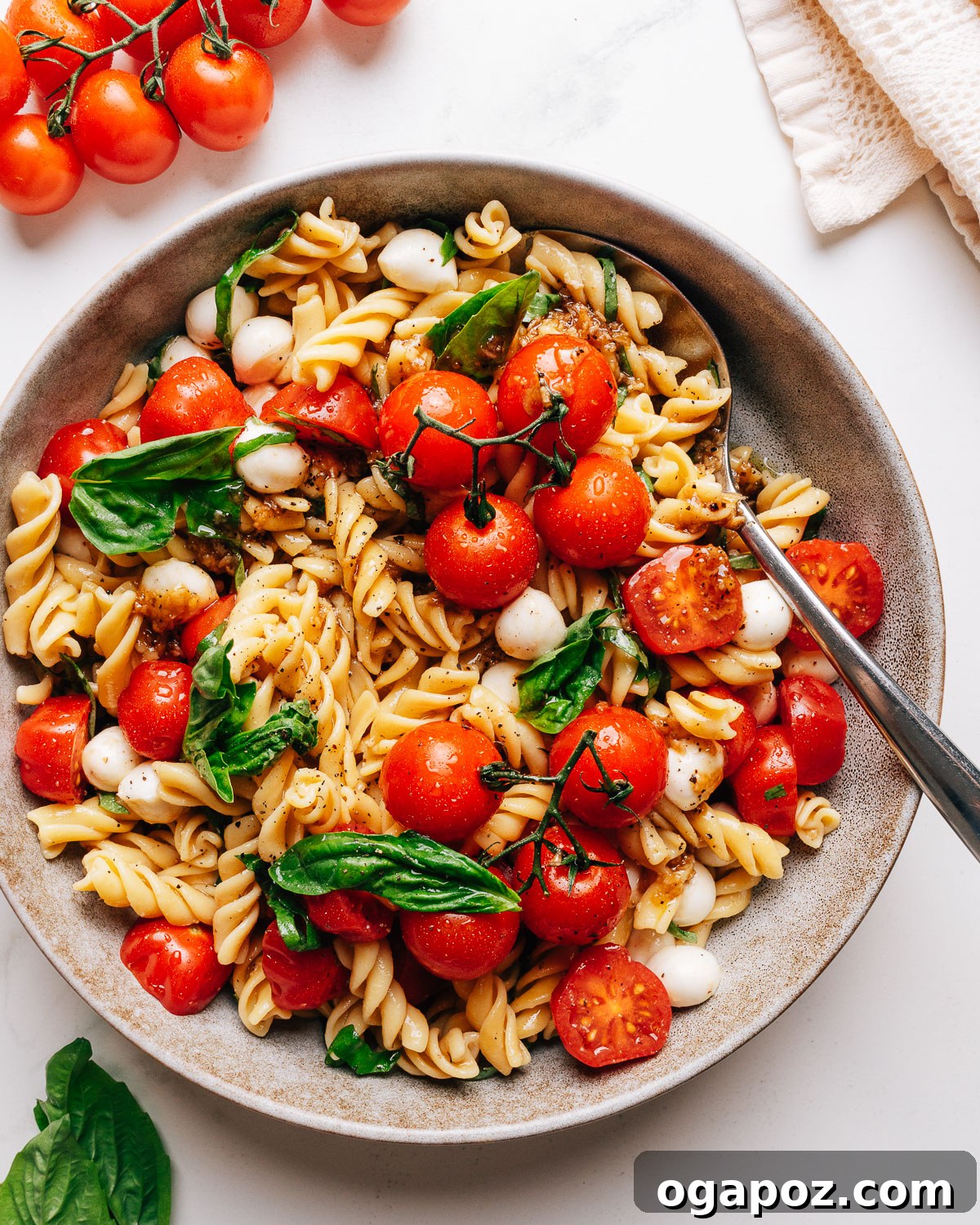 Caprese Pasta Salad with Cherry Tomatoes, Mozzarella & Basil 2 Caprese pasta salad in a bowl with cherry tomatoes, fresh mozzarella, and basil.