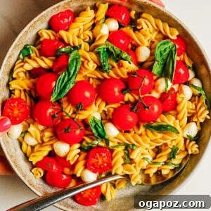 Caprese Pasta Salad with Cherry Tomatoes, Mozzarella & Basil 10 Caprese pasta salad in a bowl with cherry tomatoes, fresh mozzarella, and basil.