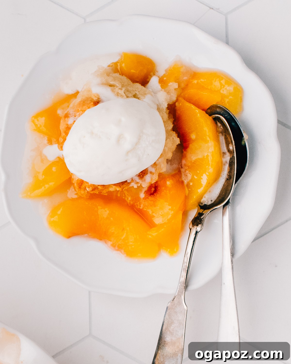Summer Fruit Dessert Recipes: Peach, Cherry and Berries 2 Peach cobbler in a baking dish with a golden biscuit topping.