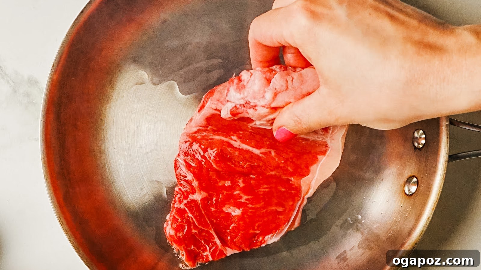 Pan-Seared Garlic Butter Steak Ready in 15 Minutes 4 Seasoned steak laid into a hot stainless pan to sear.