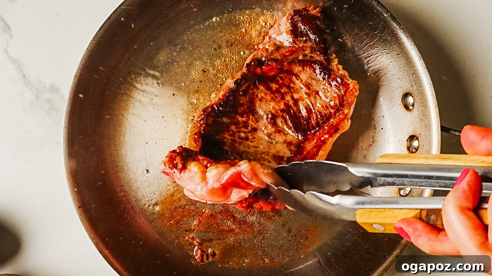 Pan-Seared Garlic Butter Steak Ready in 15 Minutes 5 Steak searing with a deep brown crust, lifted with tongs.