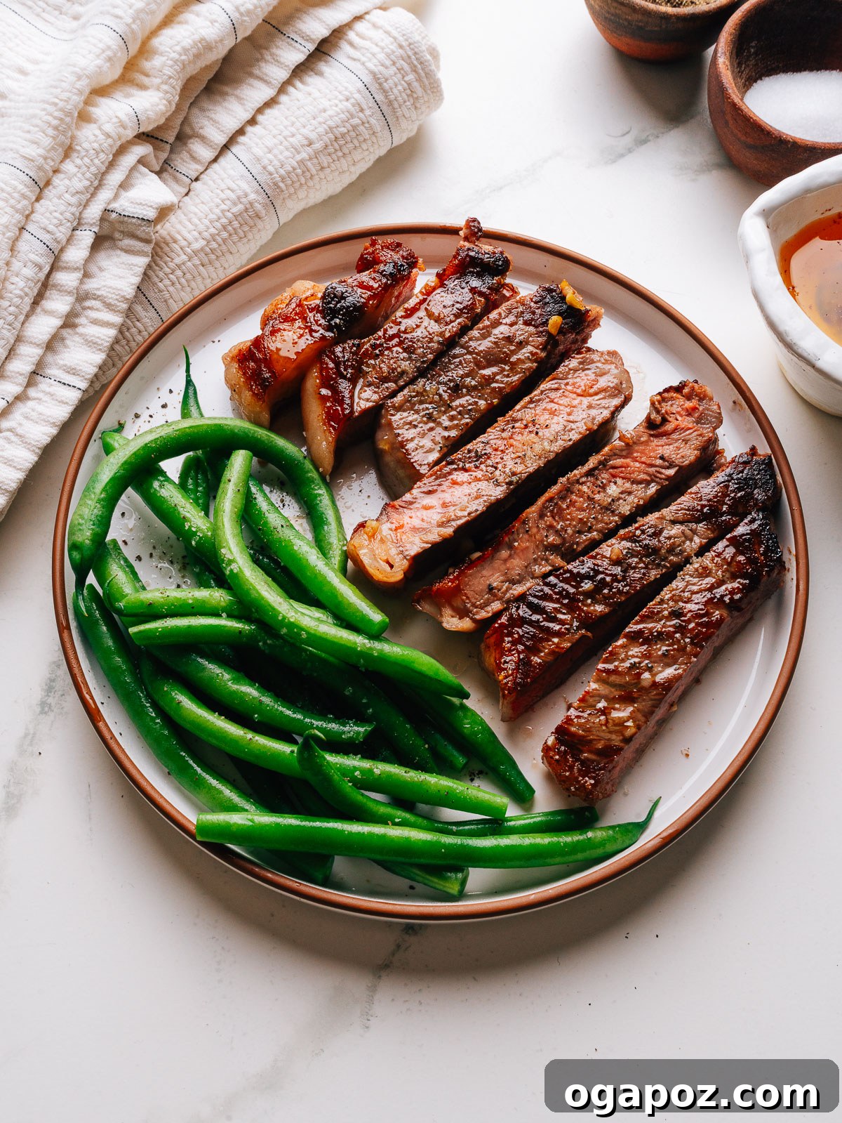 Pan-Seared Garlic Butter Steak Ready in 15 Minutes 7 Garlic butter steak sliced and plated with green beans and pan butter.