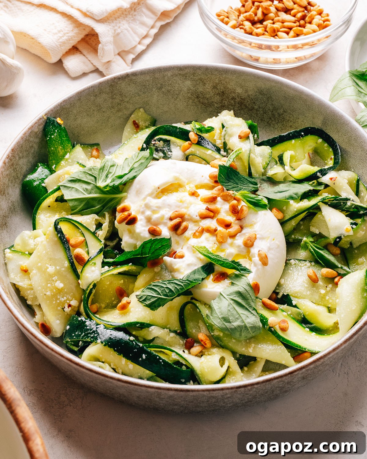 Crisp Raw Zucchini Ribbon Salad with Lemon and Herbs 10 Zucchini salad with creamy burrata, toasted pine nuts, and fresh herbs in a bowl.