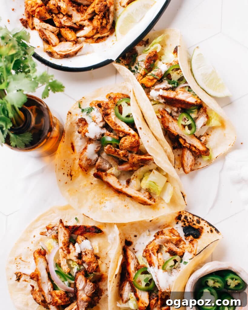 Chicken street tacos topped with onion, cilantro, and lime.