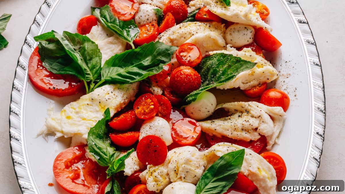 Authentic Caprese Salad with Cherry Tomatoes 6 Caprese salad recipe with cherry tomatoes on a platter with torn mozzarella, ripe tomatoes and fresh basil.
