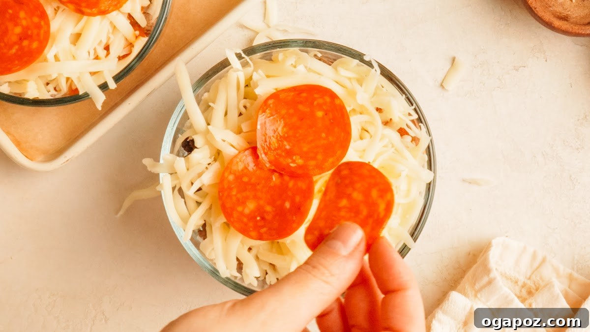 Loaded Cheesy Pizza Bowl Recipe for Weeknight Dinner 9 Step 3: pepperoni layered over shredded mozzarella in a glass pizza bowl.