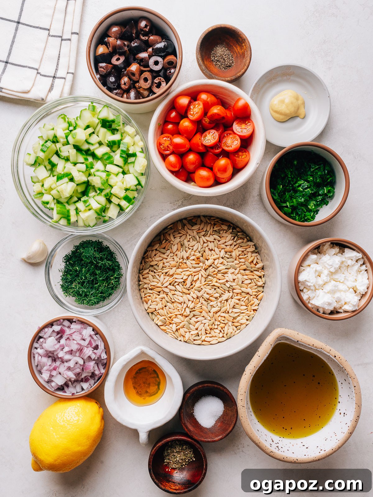 Mediterranean Orzo Salad with Feta, Olives & Cherry Tomatoes 3 Orzo pasta salad ingredients with with cucumber, cherry tomatoes, olives and feta in a bowl.