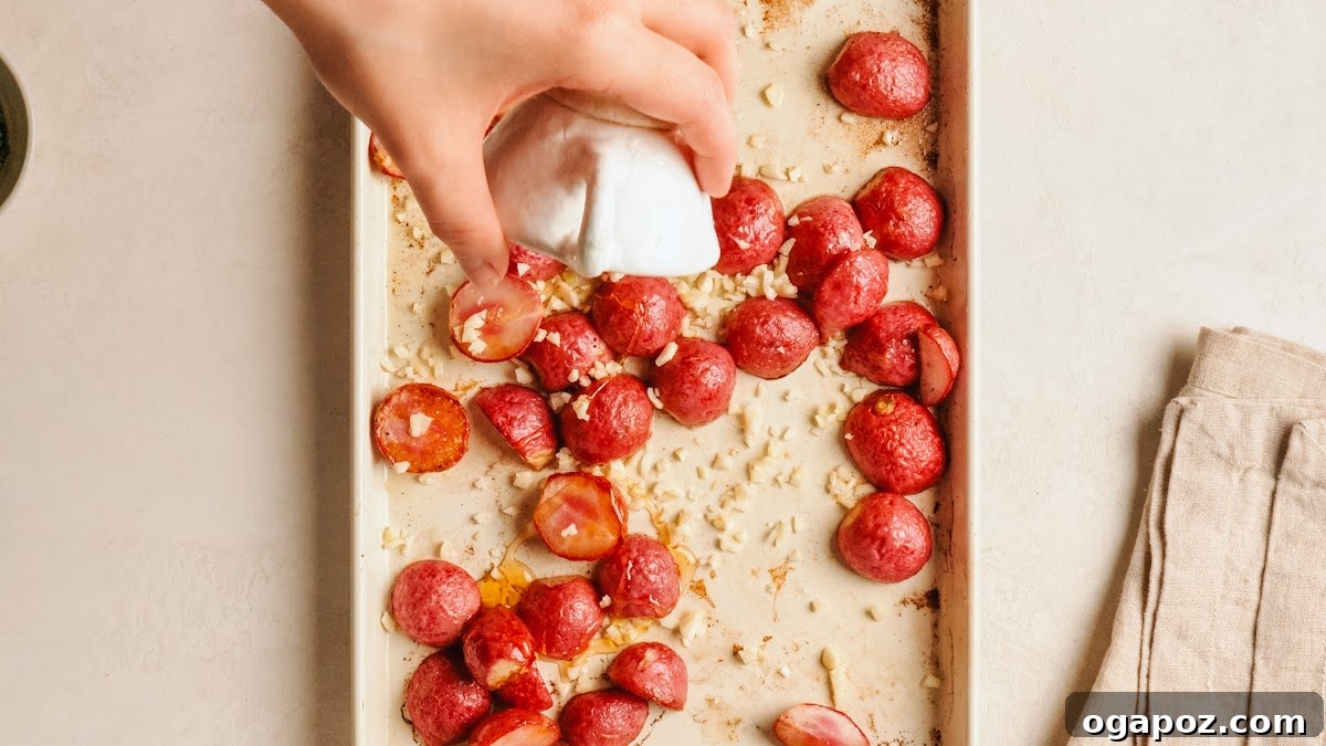 Crispy Oven-Roasted Radishes with Garlic and Herbs 7 Drizzling honey over roasted radishes on a baking sheet.