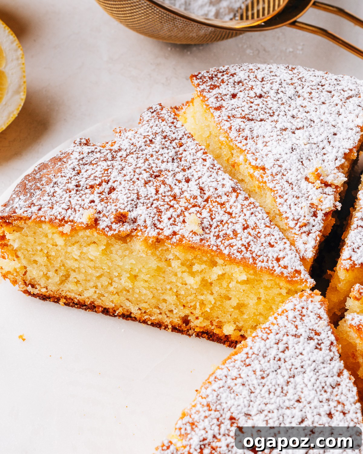 Moist Lemon Olive Oil Cake Recipe with Citrus Glaze 2 A lemon olive oil cake dusted with powdered sugar and sliced.