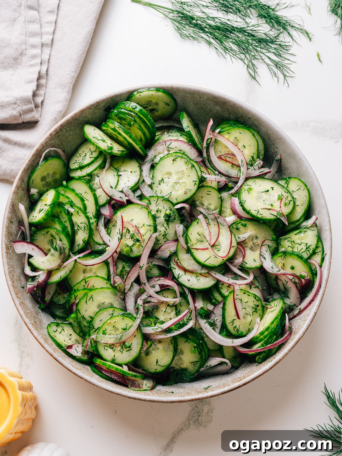 Cucumber Dill Salad with Vinegar Dressing 2 Cucumber dill salad with vinegar in a bowl with red onion and fresh dill.