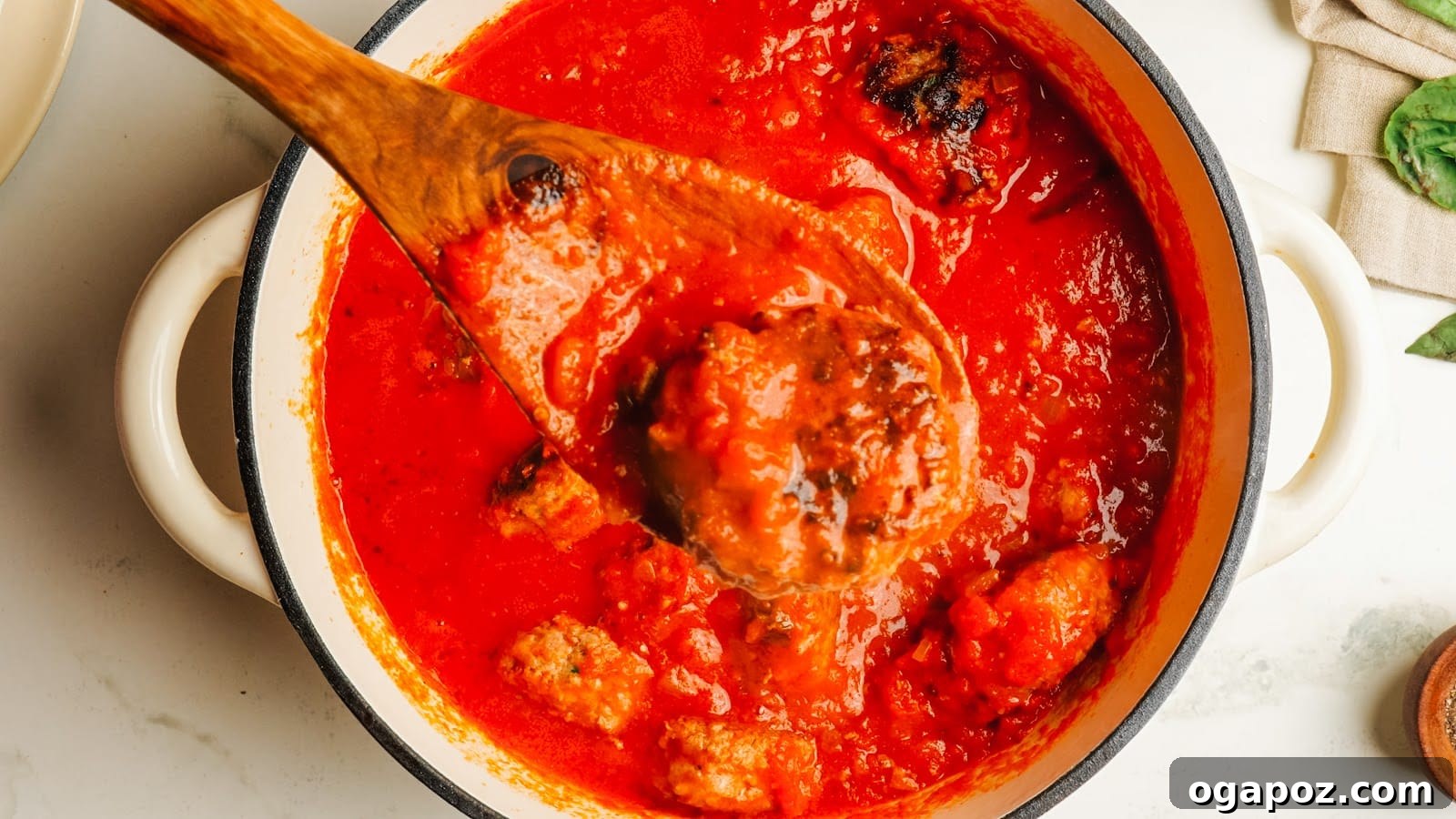 Classic Italian Meatballs in Rich Tomato Sauce 10 Browned meatballs simmering in the tomato sauce in a Dutch oven.