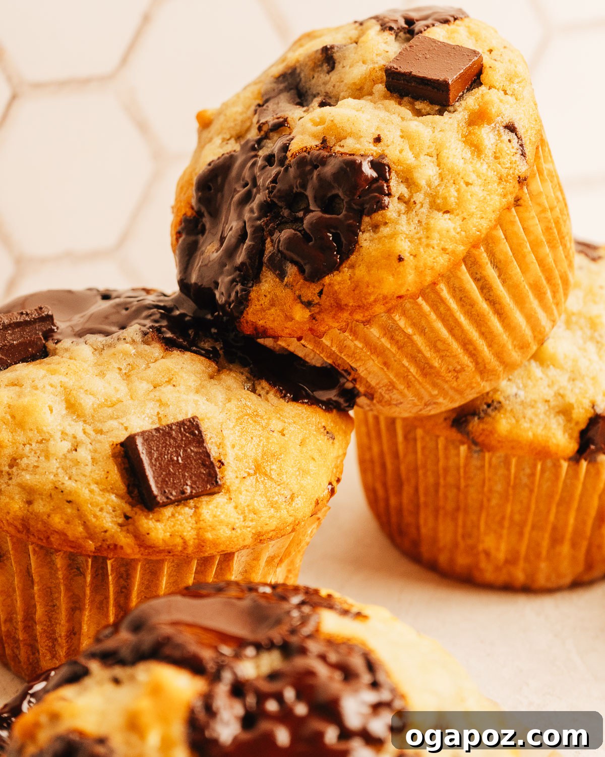 One-Bowl Banana Chocolate Chunk Muffins Soft and Moist 3 Banana chocolate chip muffins topped with melted chocolate chunks.