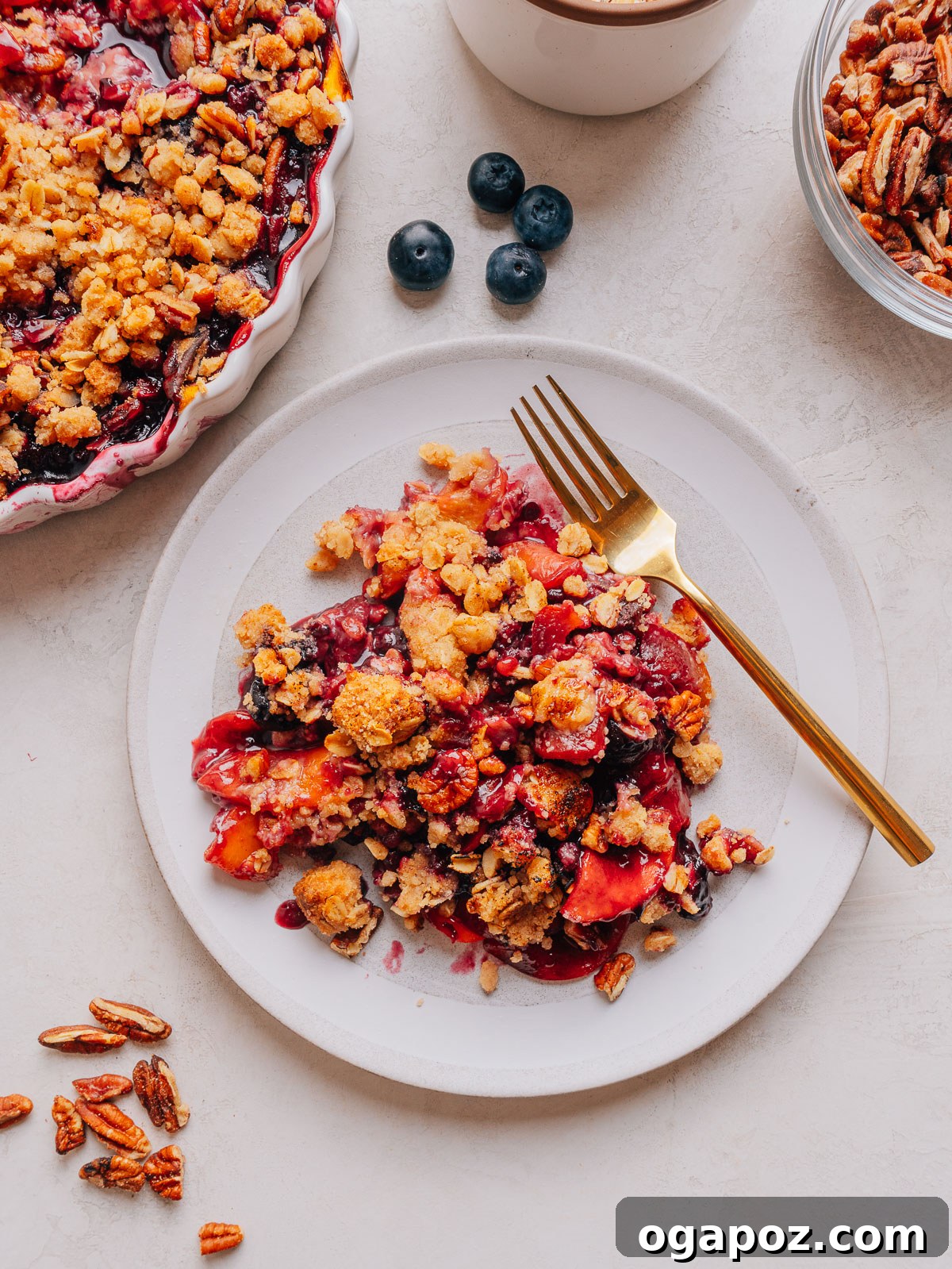 Peach Blueberry Crisp with Brown Sugar Oat Topping 2 Baked Peach and Blueberry crisp with a deep golden topping on plates with a fork.