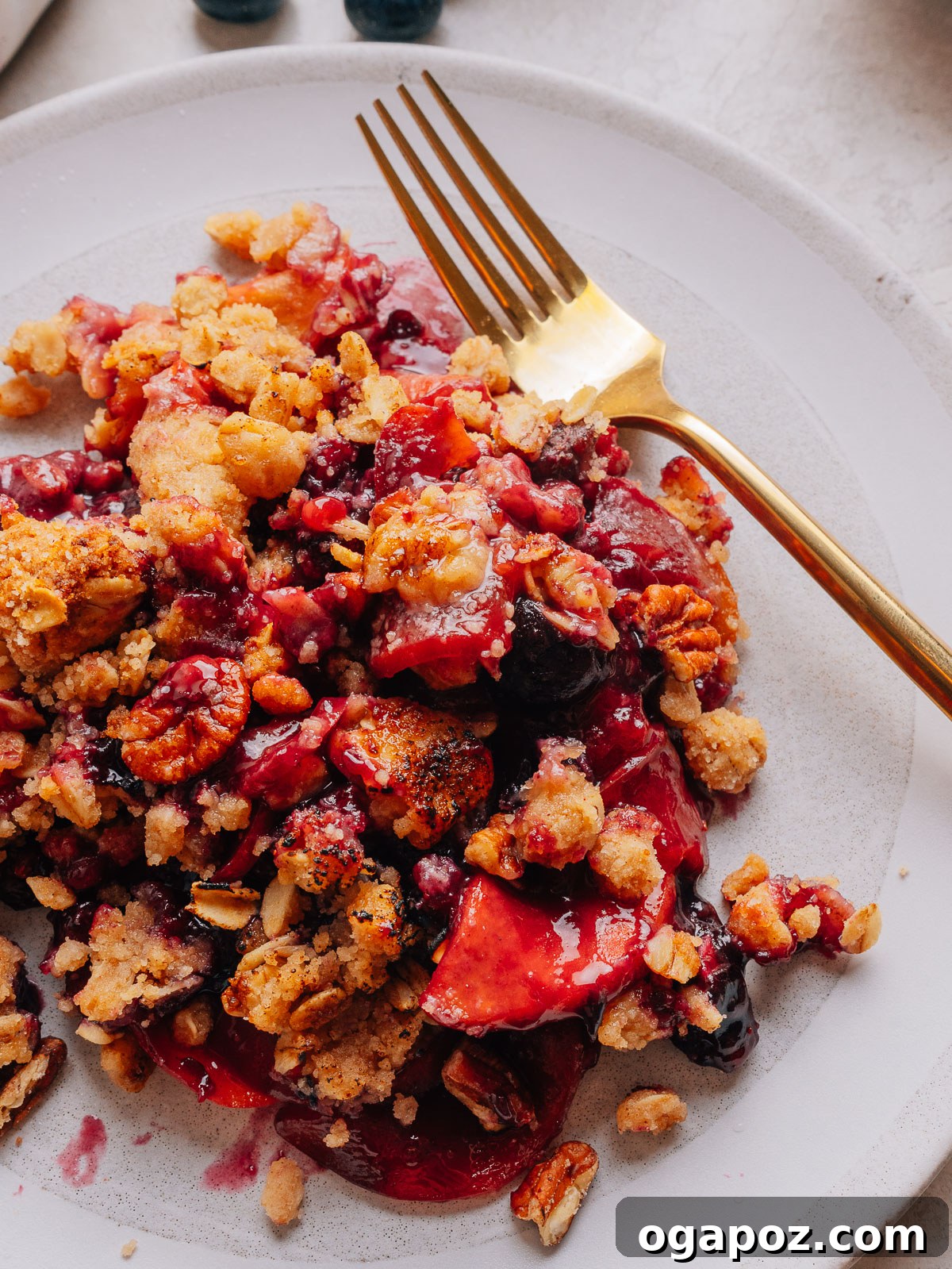Peach Blueberry Crisp with Brown Sugar Oat Topping 11 Baked Peach and Blueberry crisp with a deep golden topping on plates with a fork.