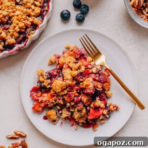Peach Blueberry Crisp with Brown Sugar Oat Topping 13 Baked Peach and Blueberry crisp with a deep golden topping on plates with a fork.