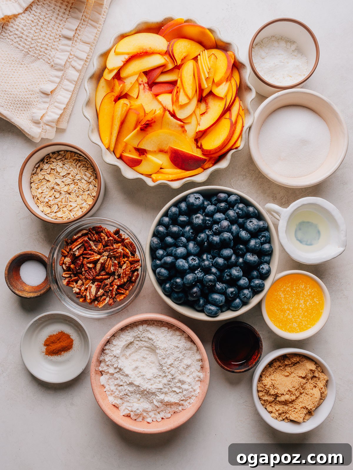 Peach Blueberry Crisp with Brown Sugar Oat Topping 3 Ingredients for Peach Blueberry Crisp measured into small bowls including sliced peaches, blueberries, rolled oats and brown sugar.