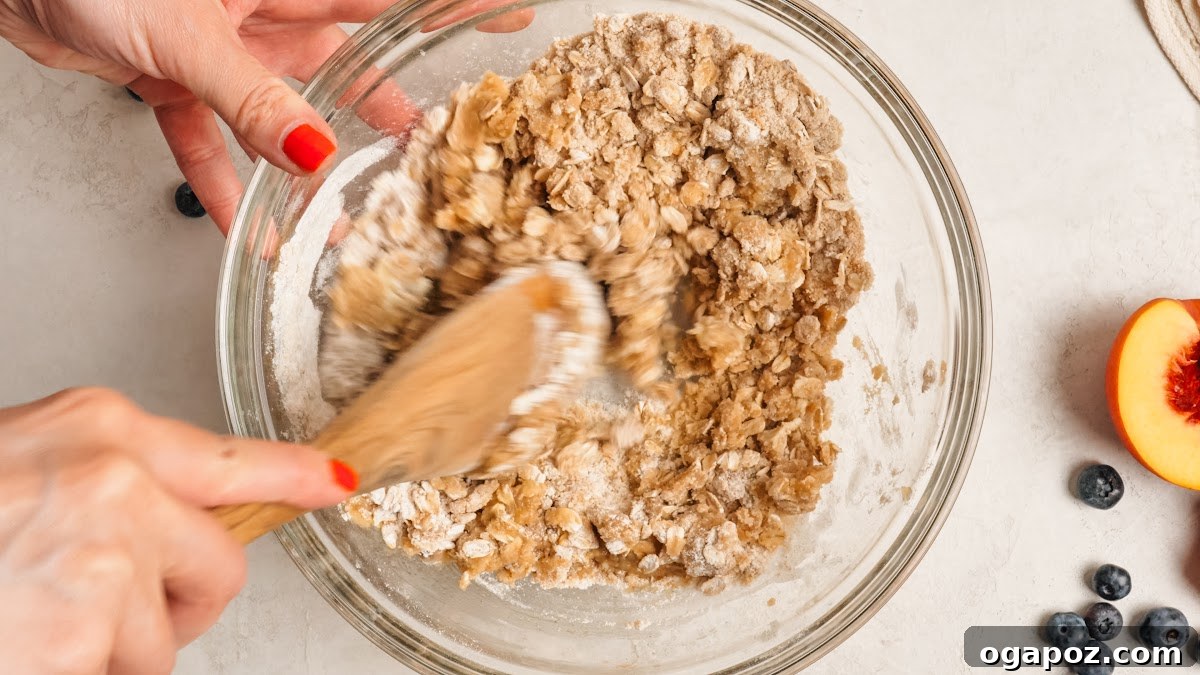 Peach Blueberry Crisp with Brown Sugar Oat Topping 7 Stirring the oat topping with a fork until shaggy clumps form.
