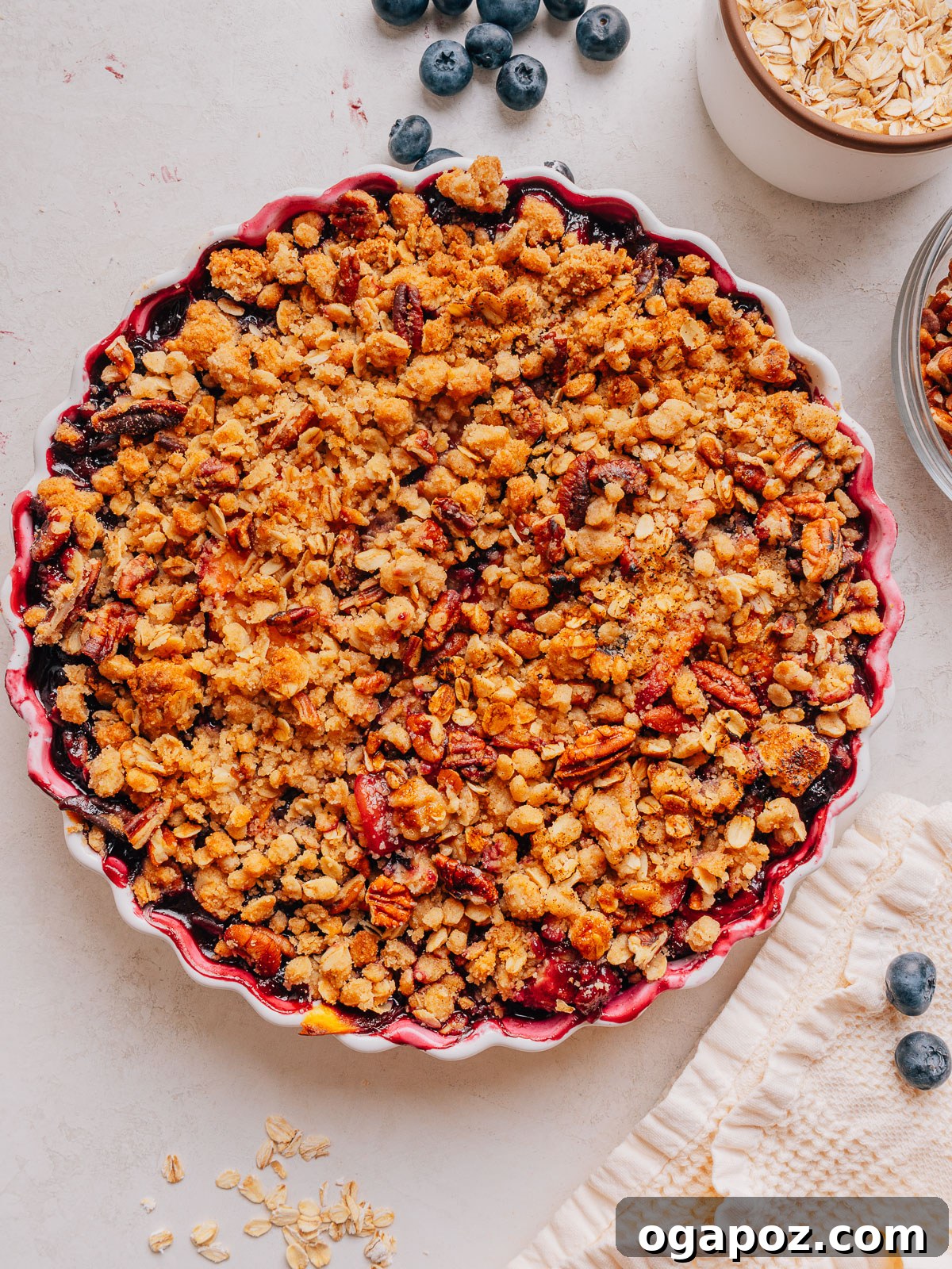 Peach Blueberry Crisp with Brown Sugar Oat Topping 10 Overhead view of a baked peach and blueberry crisp with a crunchy pecan oat topping.