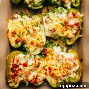 Classic Stuffed Green Peppers with Rice and Ground Beef 11 Stuffed green peppers with melted mozzarella in a baking dish.
