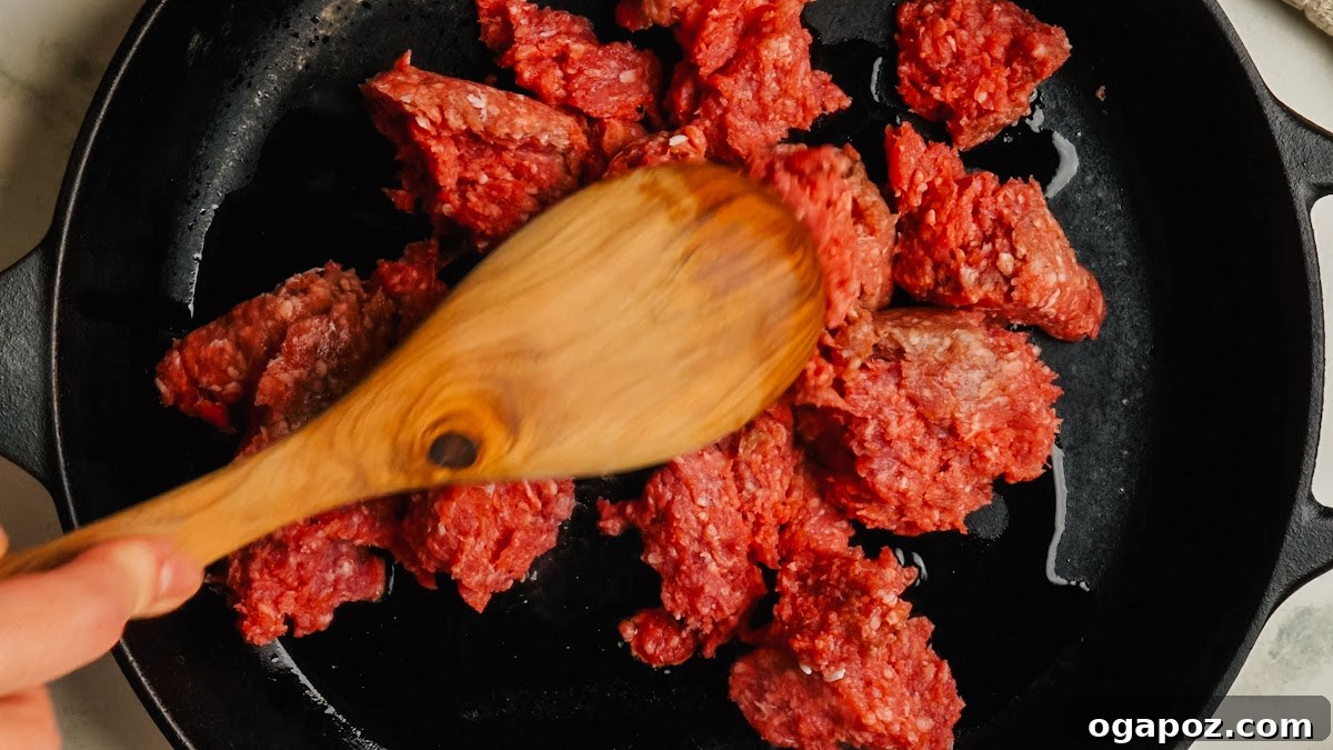 Classic Stuffed Green Peppers with Rice and Ground Beef 5 Browning ground beef in a cast iron skillet.