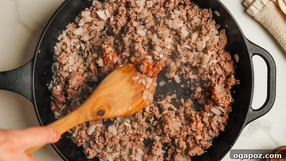 Classic Stuffed Green Peppers with Rice and Ground Beef 6 Cooking ground beef with chopped onion in a skillet.