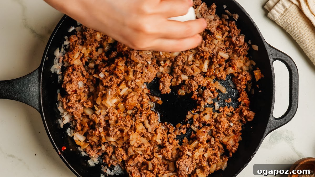 Classic Stuffed Green Peppers with Rice and Ground Beef 7 Seasoned ground beef filling cooking in a skillet.
