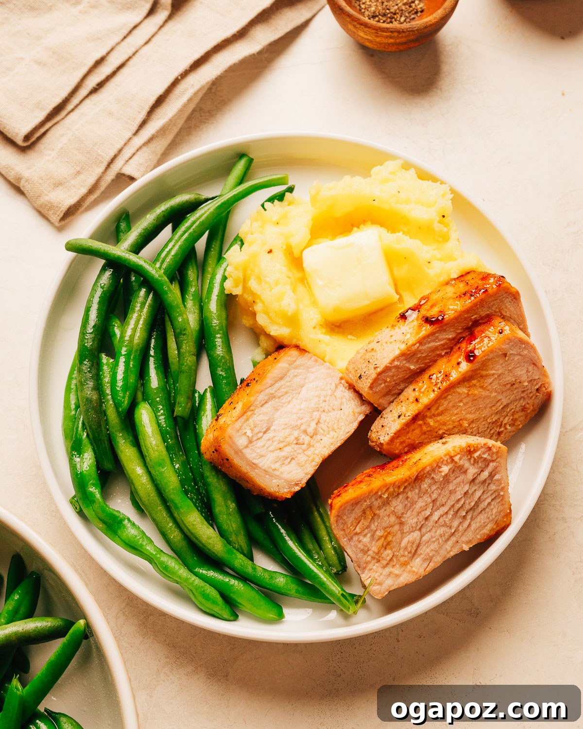 Oven-Baked Brown Sugar Boneless Pork Chops 2 Juicy baked boneless pork chops on a plate.