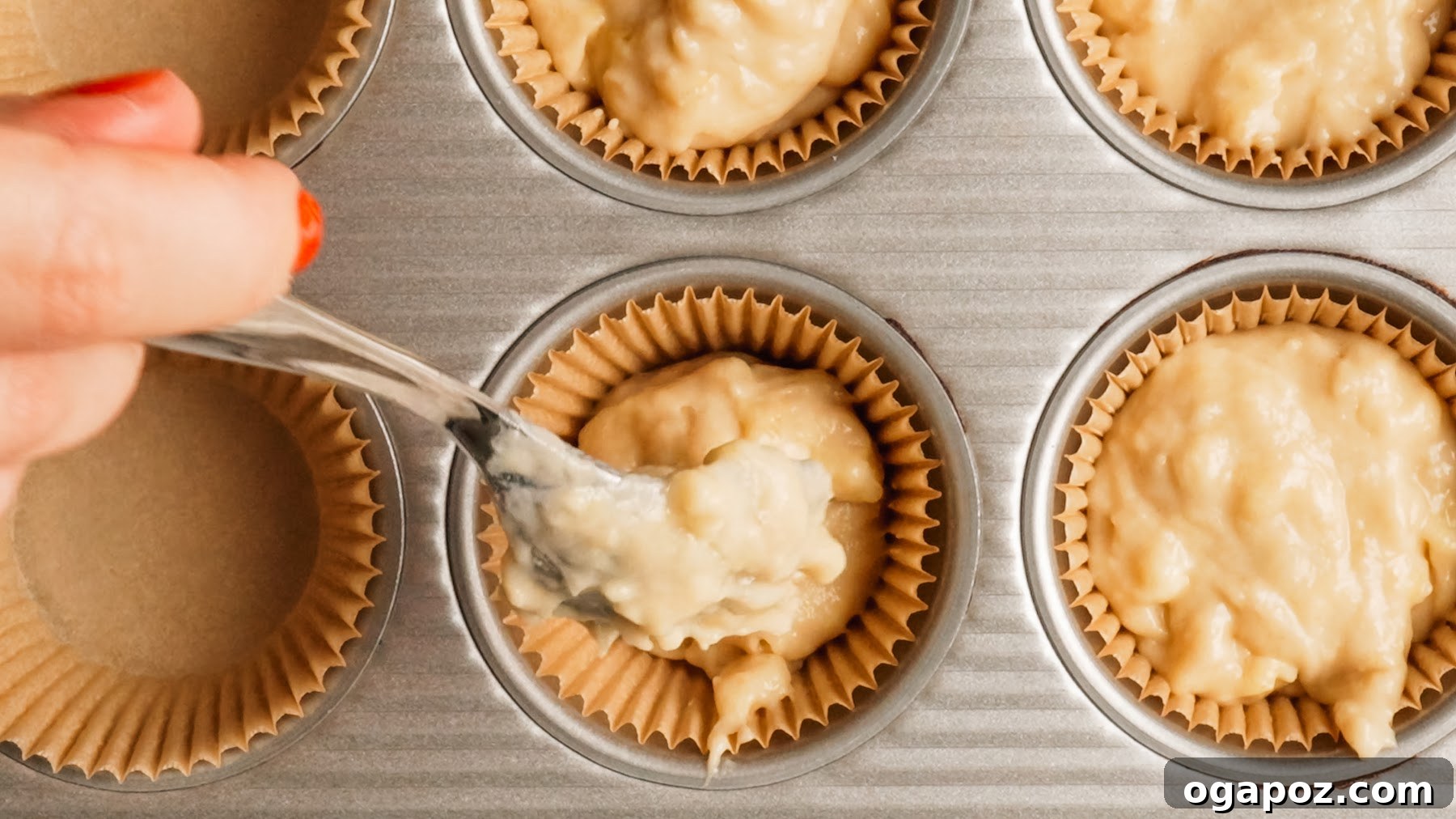 Moist Banana Bread Muffins That Stay Fresh for Days 6 Spooning banana muffin batter into a paper-lined muffin tin.